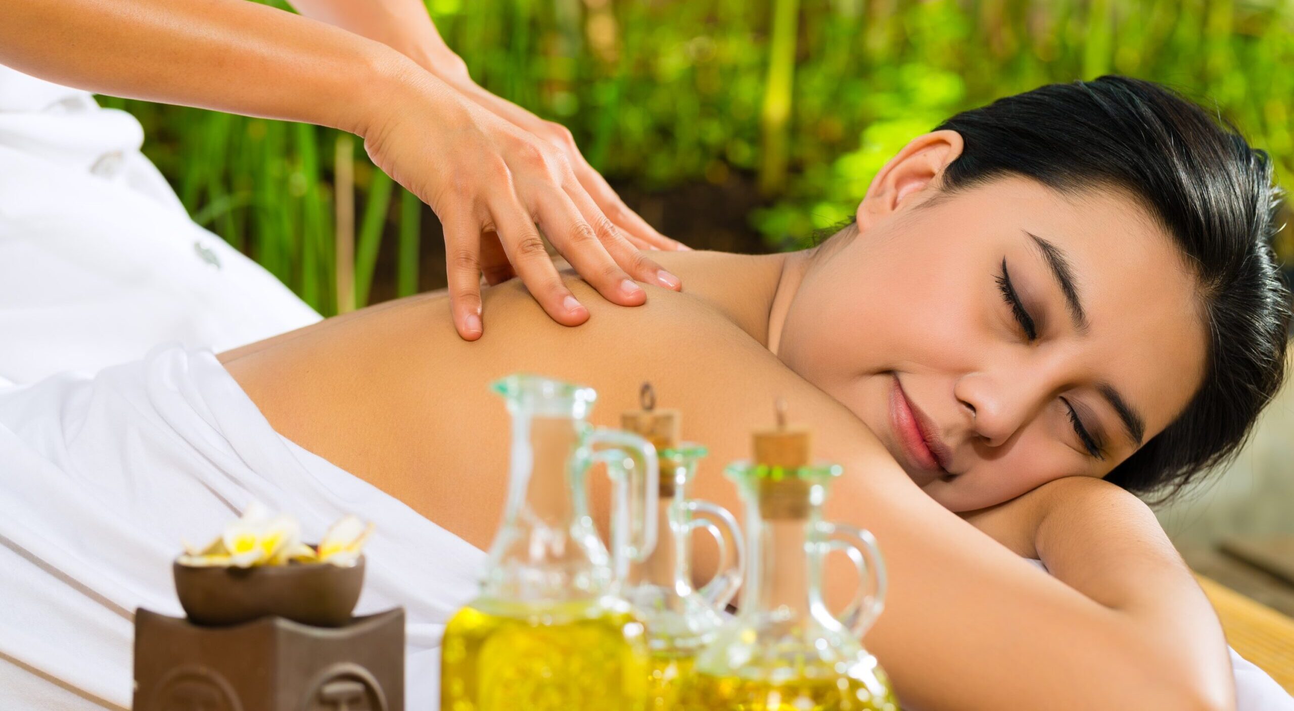asian-woman-having-massage-tropical-setting-less-scaled-1