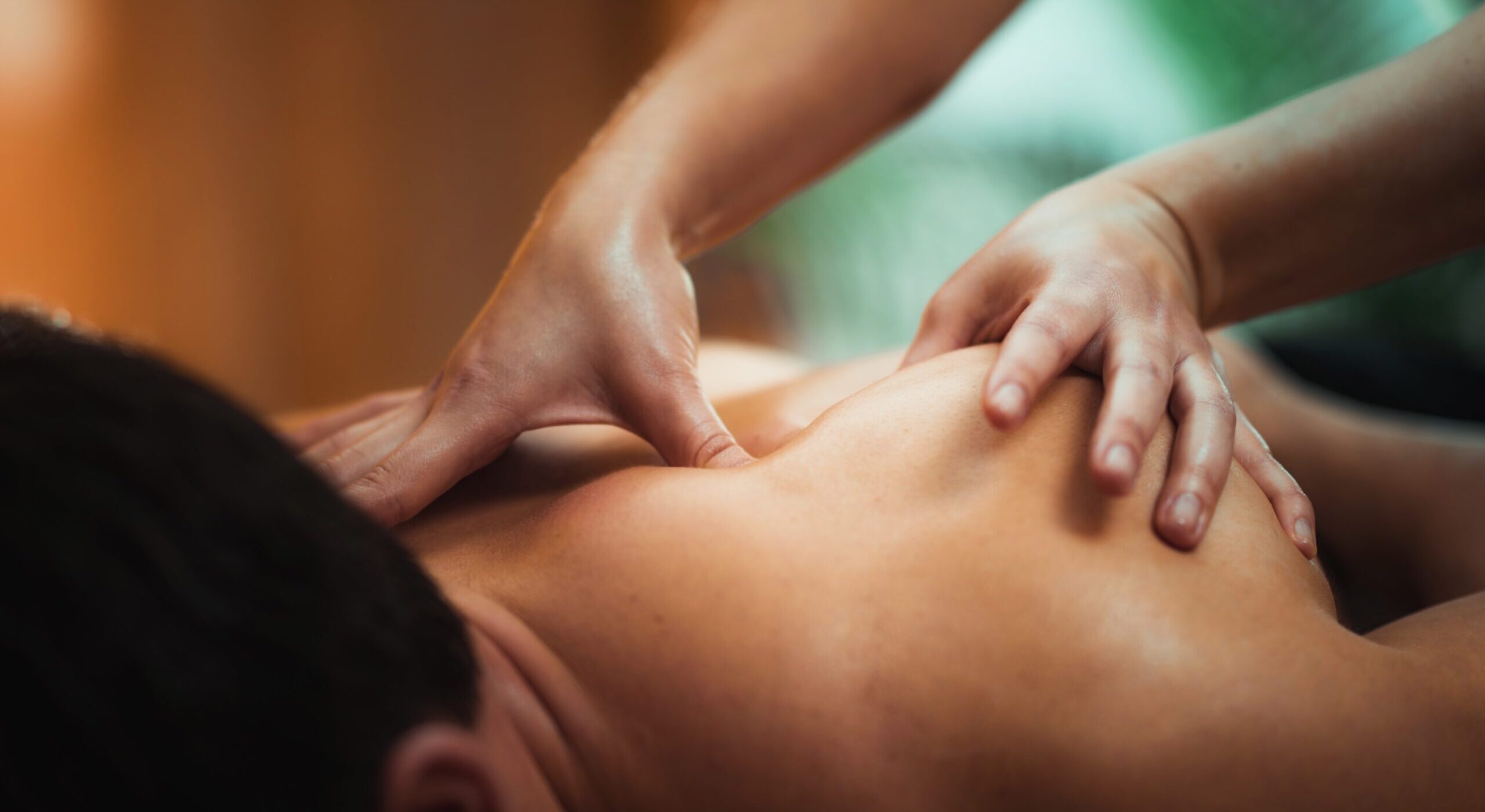 physiotherapist-massaging-male-patient-with-injured-shoulder-blade-muscle-sports-injury-treatment-less-scaled-1